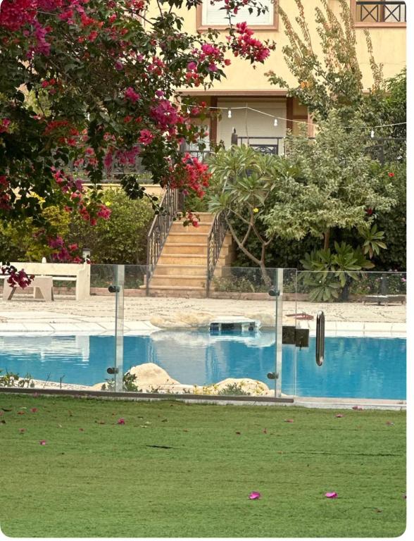 a house with a swimming pool in front of a building at Cozy room in Cairo