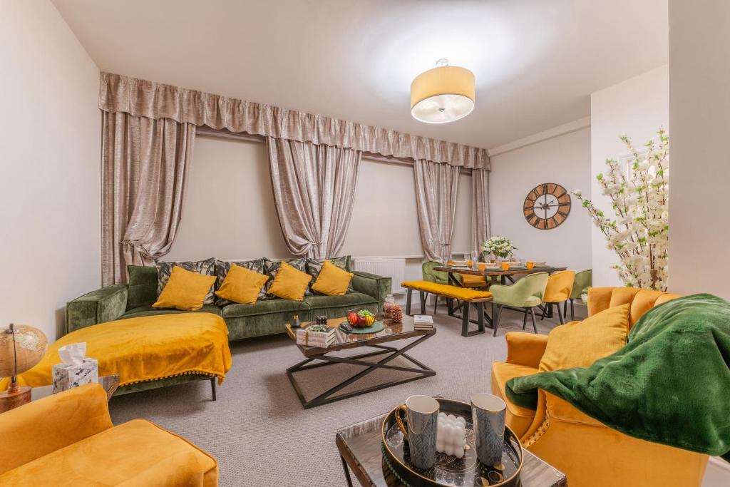 a living room with a green couch and yellow pillows at Stylish Spacious Retreat Luxury 2 Bedroom Haven 2 in London