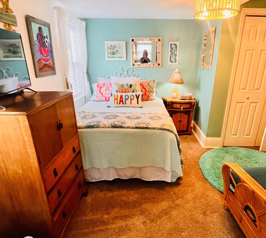 a bedroom with a bed with a happy pillow on it at Pearls Pad - Beautiful 1 bedroom apartment- 1 block to beach in Tybee Island