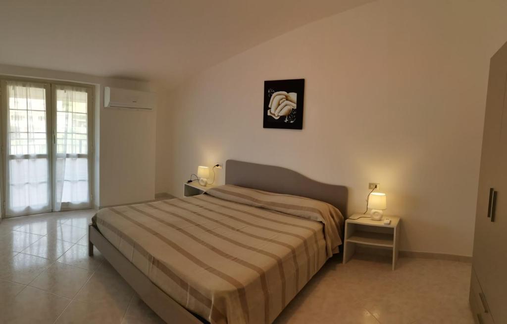 1 dormitorio con 1 cama grande y 2 lámparas en Le Palme di Riace, en Riace Marina