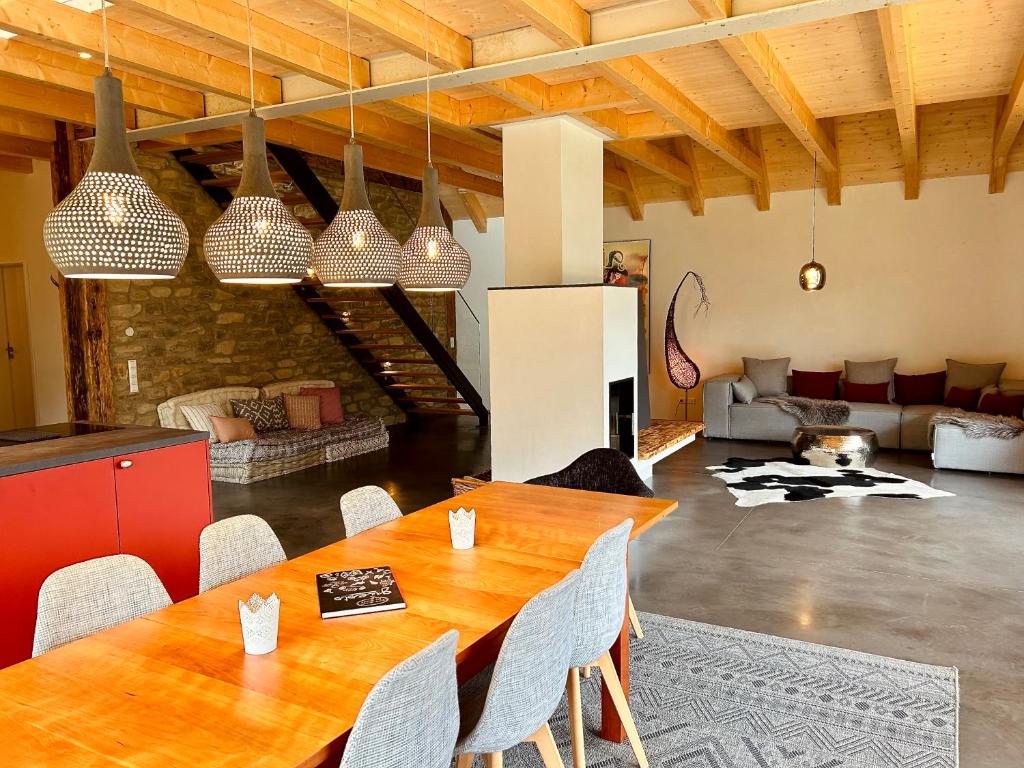 uma sala de estar com uma mesa de madeira e cadeiras em Ferienwohnung im Loft-Style mit Sauna im historischen Schwarzwaldhof em Simonswald