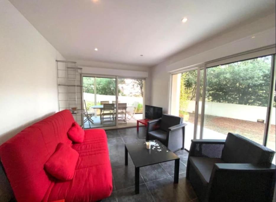 un salon avec un canapé rouge et une table dans l'établissement T3 Rdc Accès Plage à 50 m - Rupione, à Pietrosella