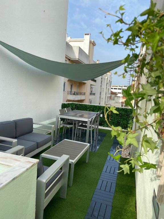 a patio with tables and chairs on a building at Bemar Loft in Costa da Caparica