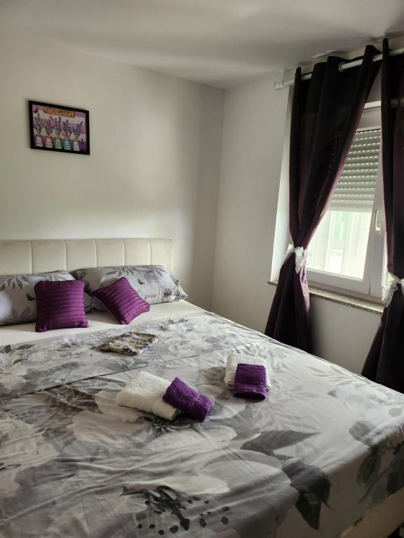 a bedroom with a large bed with purple pillows at Apartma Aleksandra in Sečovlje