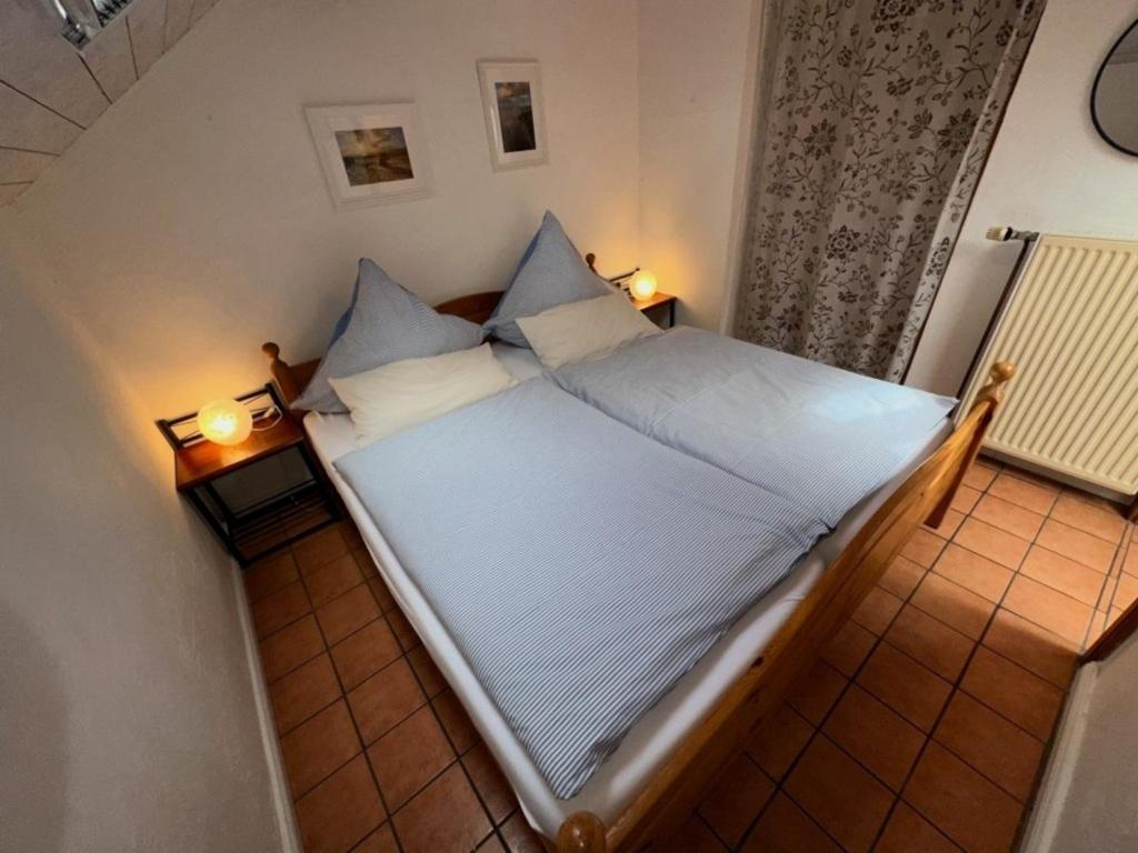 duże łóżko w pokoju z dwoma lampami w obiekcie Landhaus up de Warft - Backhaus w mieście Werdum