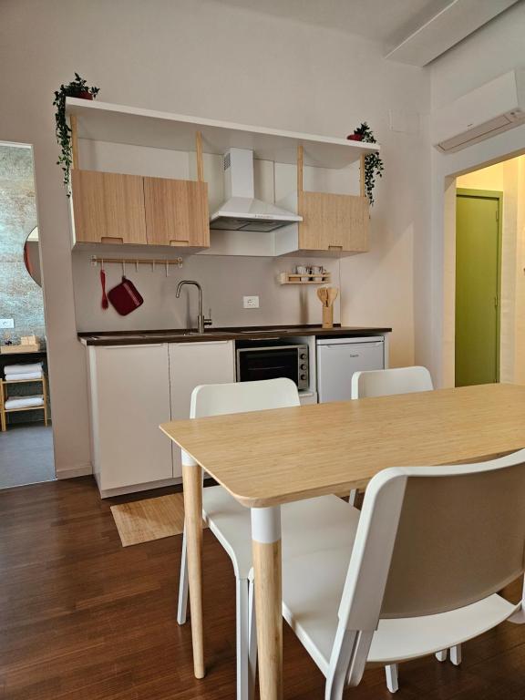een keuken en eetkamer met een houten tafel en stoelen bij Pangea in Trani
