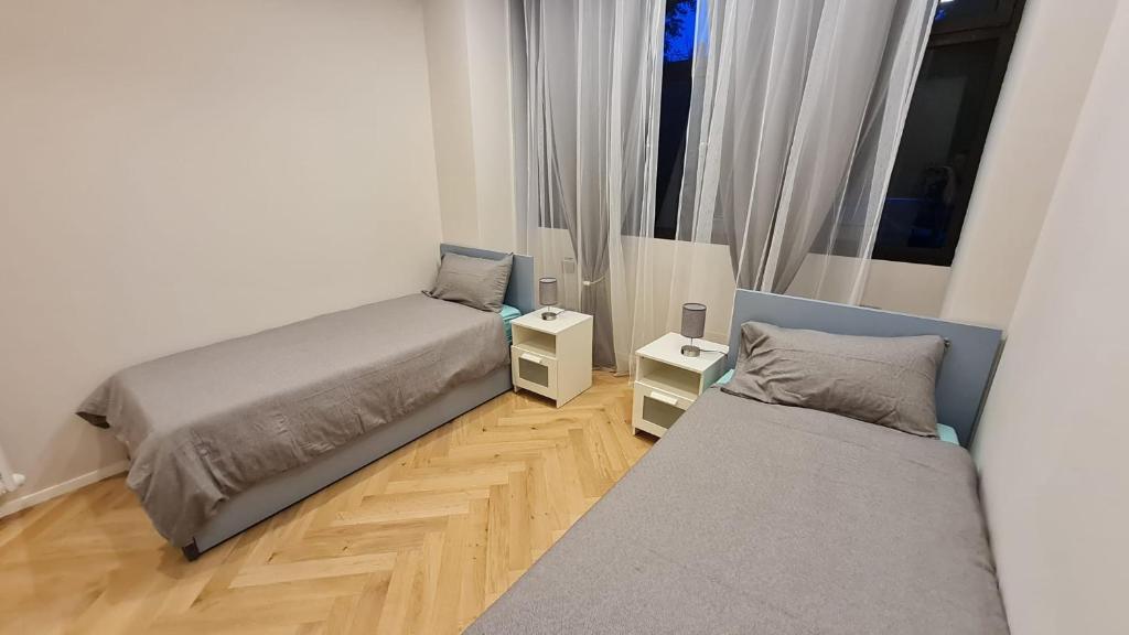 - une chambre avec 2 lits et du parquet dans l'établissement Apartament Bologna-Stadio 2, à Bologne