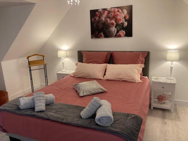 een slaapkamer met een groot bed en handdoeken bij Chambre d'Hôtes Salamandre in Lanvollon