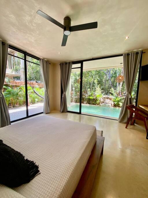 una camera con un grande letto e un ventilatore a soffitto di Little Oasis with private pool in the jungle a Chemuyil
