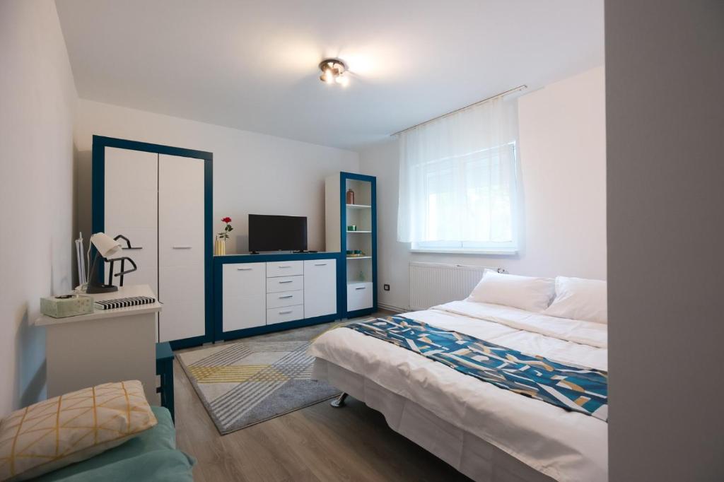 - une chambre avec un lit et une télévision dans l'établissement BIUTI, à Târgu-Mureş