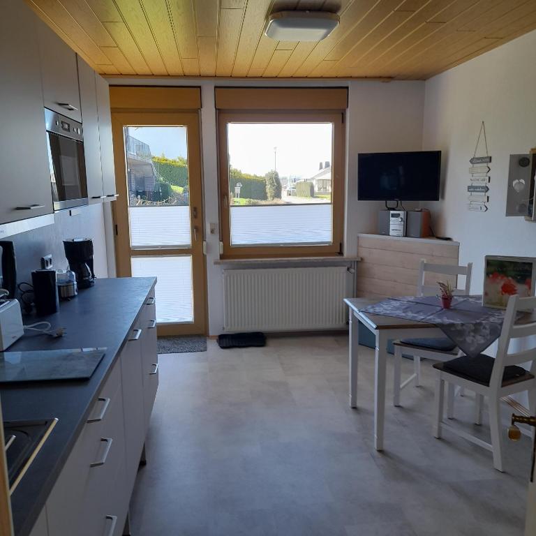 a kitchen with a table and a dining room at Bichlhof Bärfra Ferienwohnung Hunsrück in Morbach