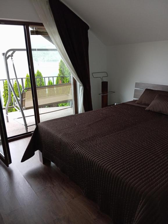 a bedroom with a large bed and a balcony at Villa Lake in Konjic