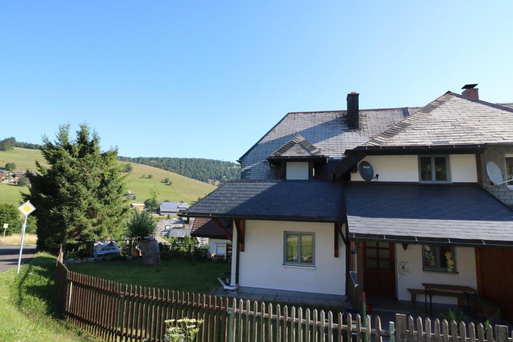 una casa con una valla de madera delante de ella en Fewo Turmblick, en Oberried