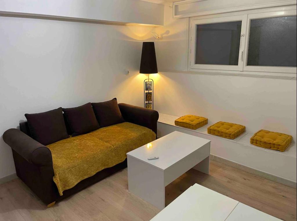 un salon avec un canapé et une table dans l'établissement Appartement en soubassement, à Port-de-Bouc