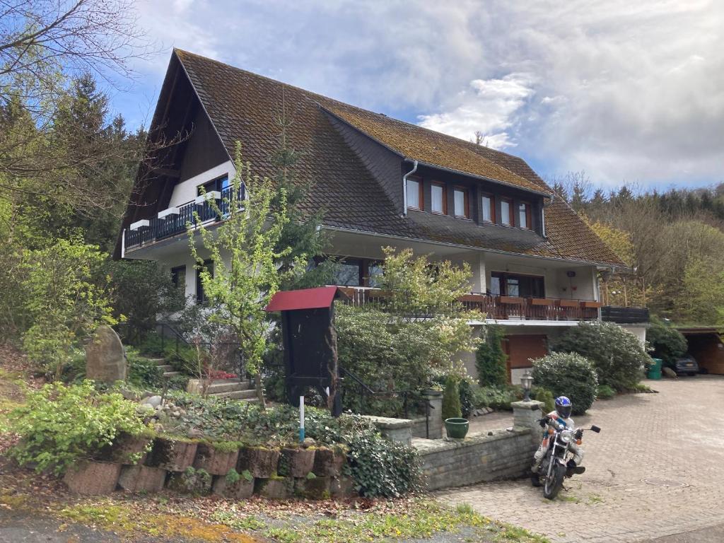 a house with a motorcycle parked in front of it at Gasthof Walhalja in Schmallenberg