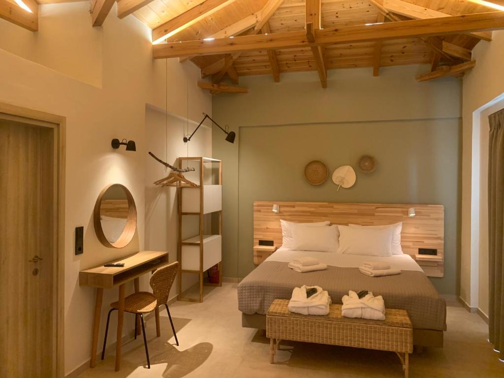 a bedroom with a bed and a desk and a mirror at Tsapini Houses in Riglia