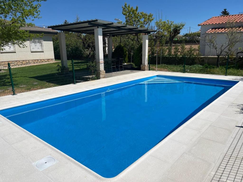 a large blue swimming pool with an umbrella at Tres Hermanos CON PISCINA PRIVADA in Pelabravo