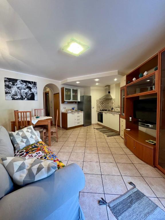 Una sala de estar con un sofá y una cocina. en Il Siciliano Apartment Taormina, en Taormina