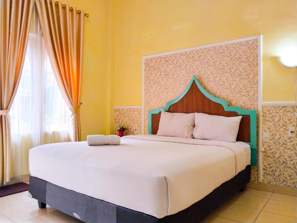 1 dormitorio con 1 cama grande en una habitación en Grand Shaqilla Syariah, en Delitua