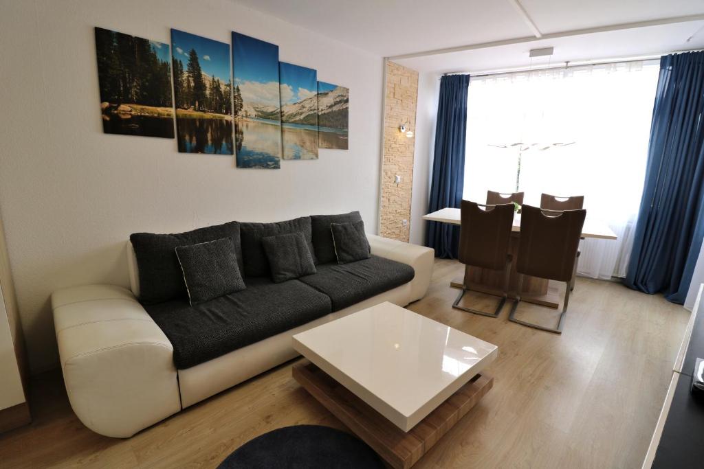 a living room with a couch and a table at Kurhotel Schluchsee App 1003 - Ferientraum - mit Indoorpool, Sauna, Schluchsee in Schluchsee