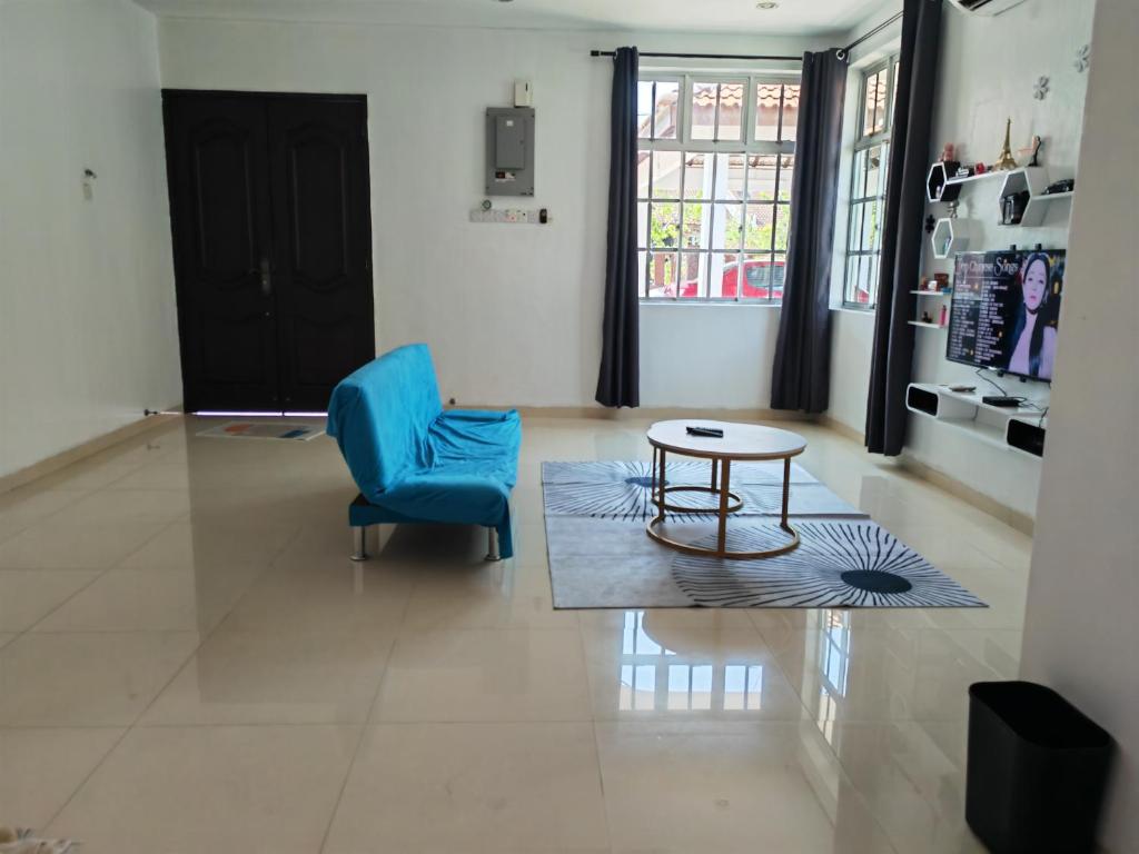 a living room with a blue chair and a table at Padang Serai Room Stay Share Bathroom in Padang Serai
