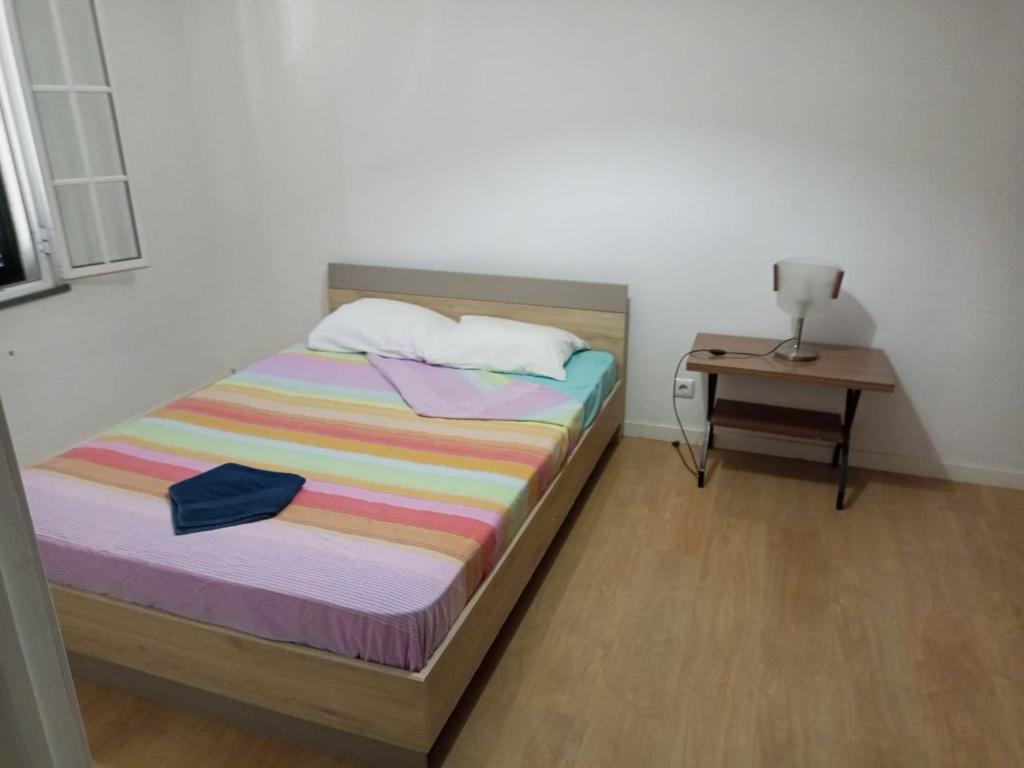 een kleine slaapkamer met een bed en een tafel bij esthela home 2 in Funchal
