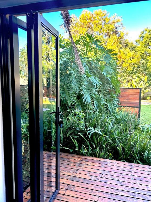 une porte coulissante en verre ouverte sur une terrasse dans l'établissement Apartment close to Menlyn Maine, à Pretoria