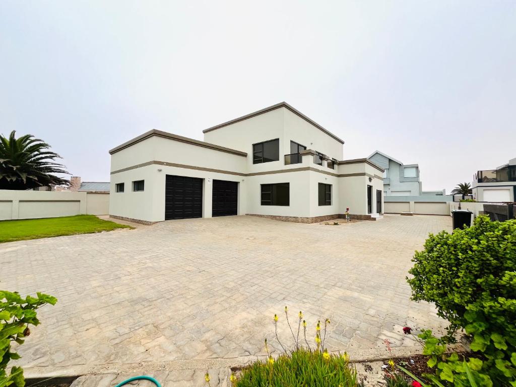 a large white house with a large driveway at Skilpadtepel in Hentiesbaai
