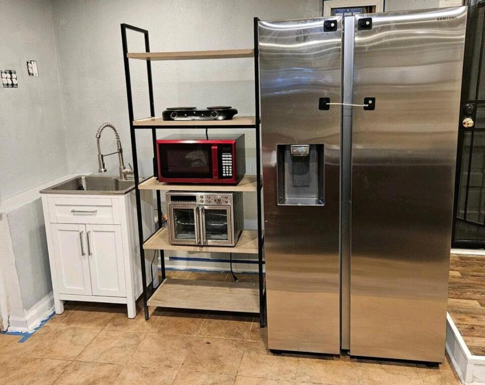 a kitchen with a stainless steel refrigerator and a microwave at PRIVATE ENTRANCE APT RooM #4 in Dallas