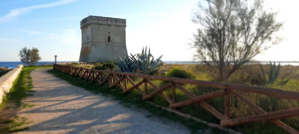 uma cerca ao lado de um edifício ao lado de uma estrada em Bilocali Approdo "Fronte Mare" e "Lato Strada" em Porto Cesareo