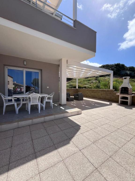 a house with a patio with a table and chairs at CASA PATTY in Castelsardo