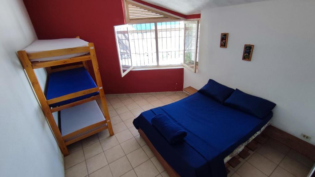 a small bedroom with a blue bed and a ladder at Maré Alta Hostel in Ubatuba