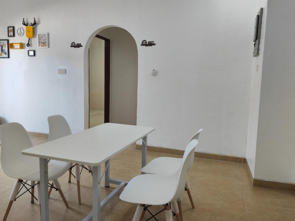 a white table and white chairs in a room at Padang Serai Roomstay Family Suite Share Bathroom804 in Padang Serai