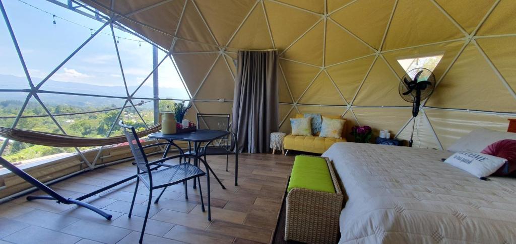 1 dormitorio en una tienda abovedada con 1 cama y 1 mesa en Ararat Eco Farm, en Coto Brus