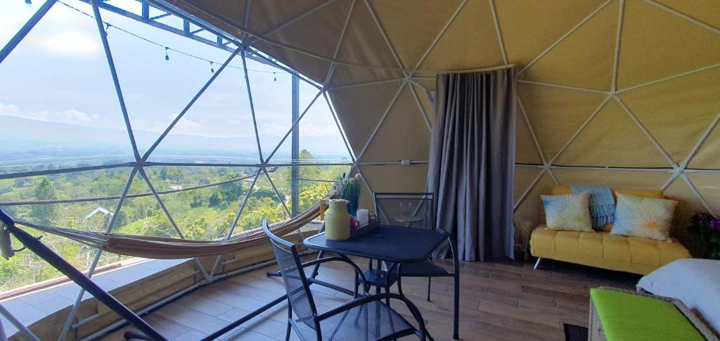 a room with a hammock in a tent with a view at Ararat Eco Farm in Coto Brus