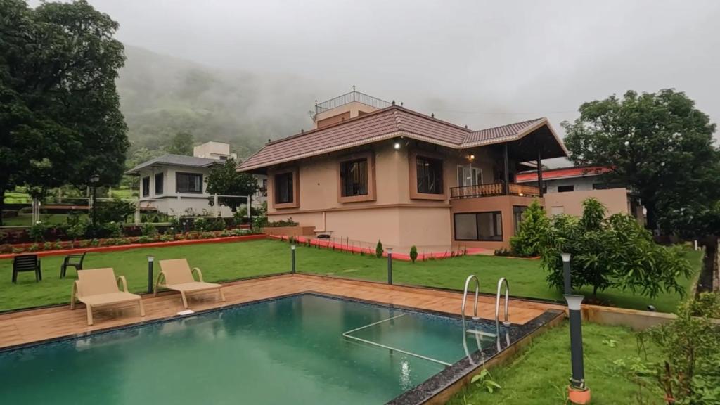 a house with a swimming pool in front of a house at BREEZE THE HILLS in Trimbak