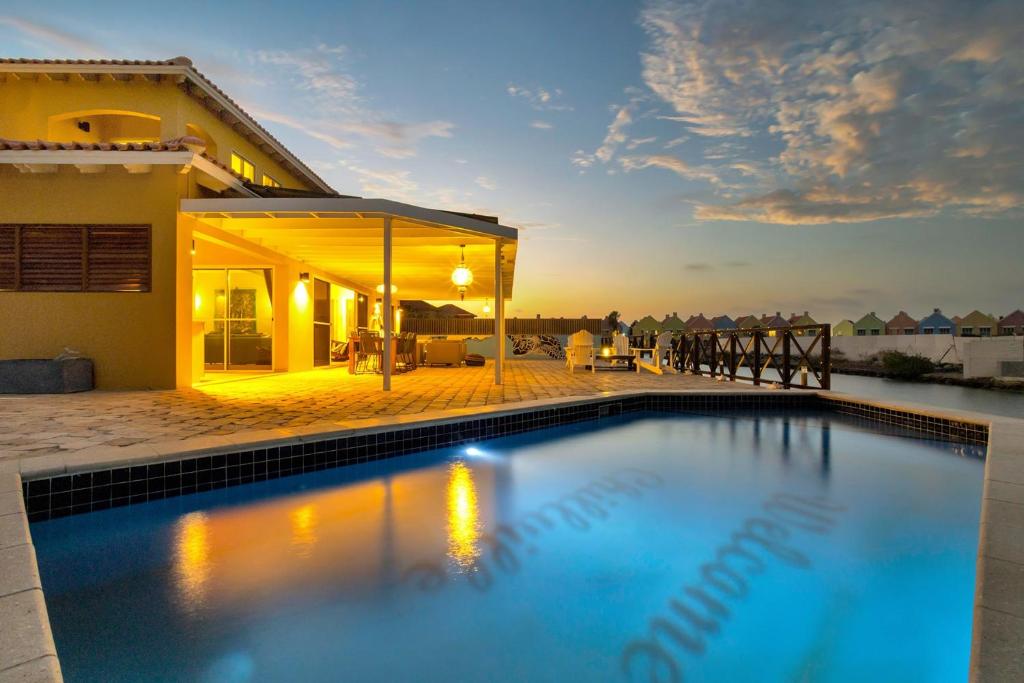 a swimming pool in front of a house at Casa Chillville in Water Villas Bonaire in Kralendijk