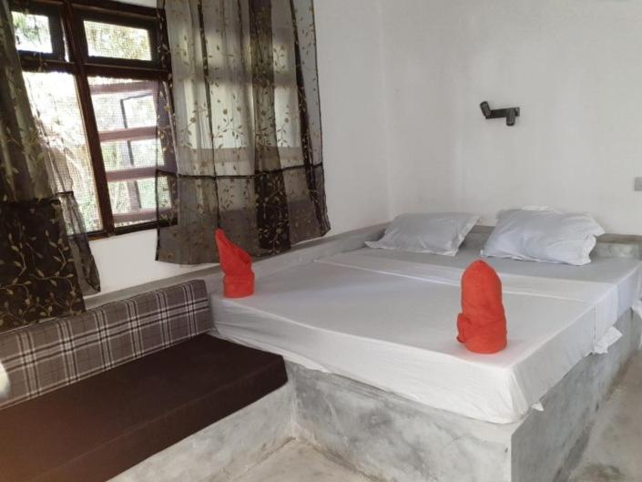 a bed with two red pillows on it in a room at Ngalawa Bush Route Hostel in Dar es Salaam