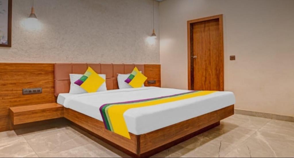 a bedroom with a large bed with colorful pillows at Hotel Abhilasha inn in Pachmarhī