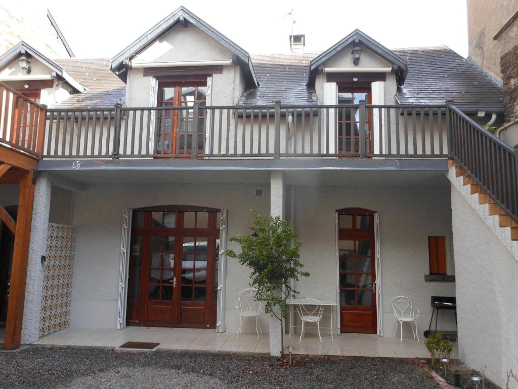 Cette maison blanche dispose d'un balcon et de deux portes. dans l'établissement Charmant meublé dans chalet montagnard, à Luchon