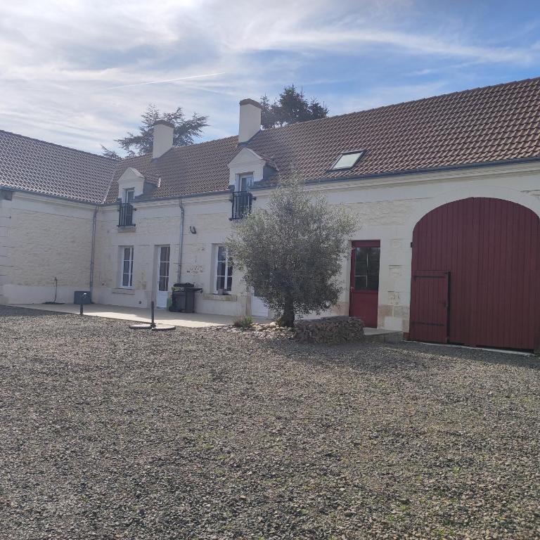 un grand bâtiment blanc avec un garage rouge dans l'établissement Maison vacances, proche Beauval, à Lye