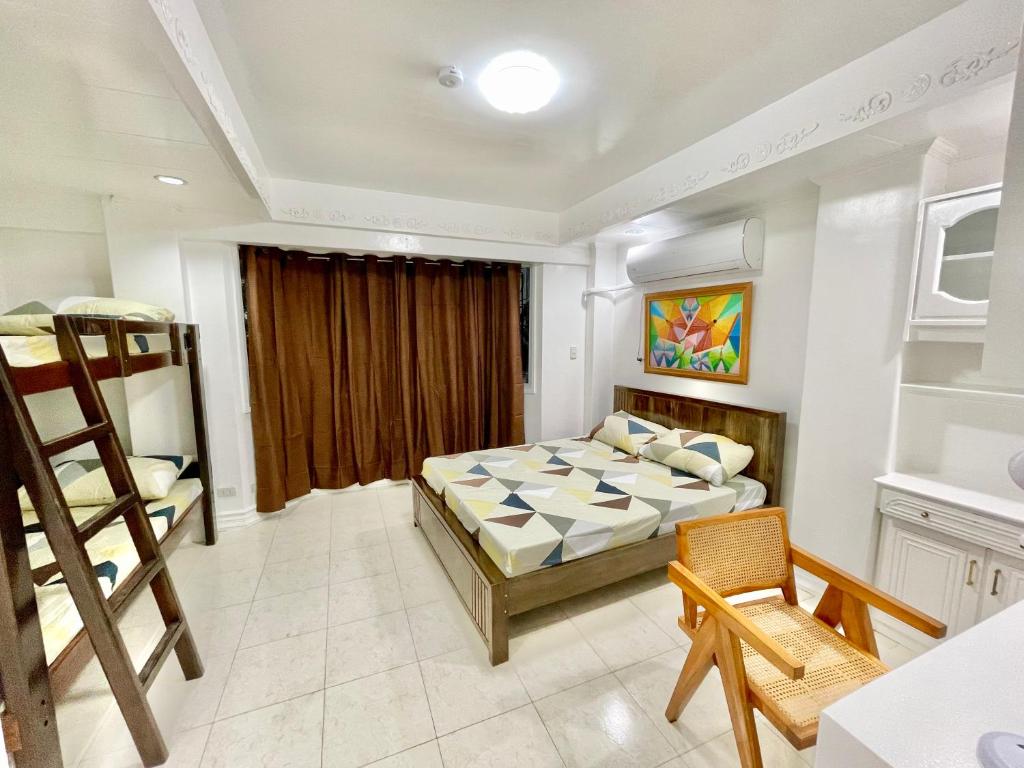 a bedroom with a bed and a table and chairs at Explore Iloilo - Accessible Apartment in Iloilo City