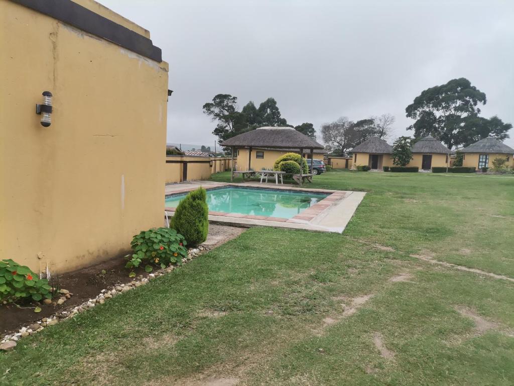 a backyard of a house with a swimming pool at Lungakaunakho Country Lodge in Port Edward
