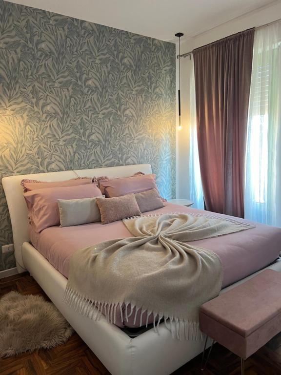 ein Schlafzimmer mit einem großen Bett mit rosa Bettwäsche in der Unterkunft Residenza San Rocco in Cavaglià