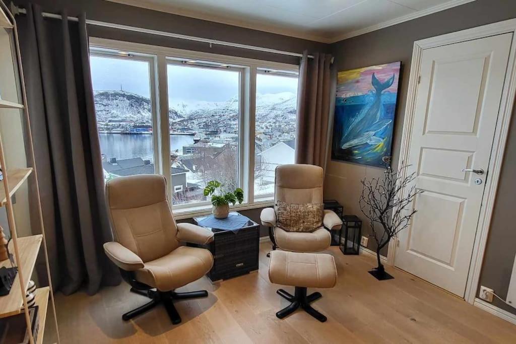 a living room with two chairs and a large window at Nice house with a great view! in Skjervøy