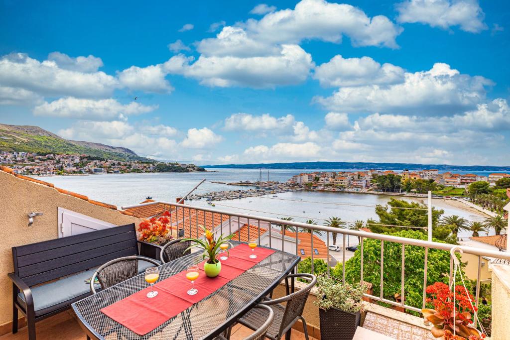 einen Balkon mit einem Tisch und Stühlen sowie Blick auf das Wasser in der Unterkunft Apartments Iskra in Split