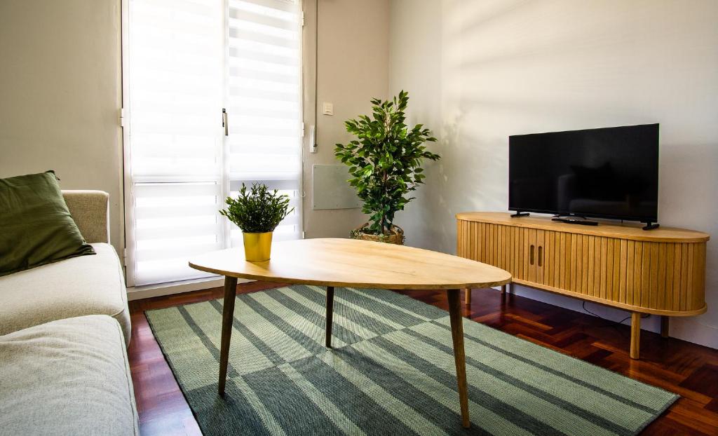 een woonkamer met een salontafel en een flatscreen-tv bij Encantador Apartamento con Wifi en Sestao in Sestao