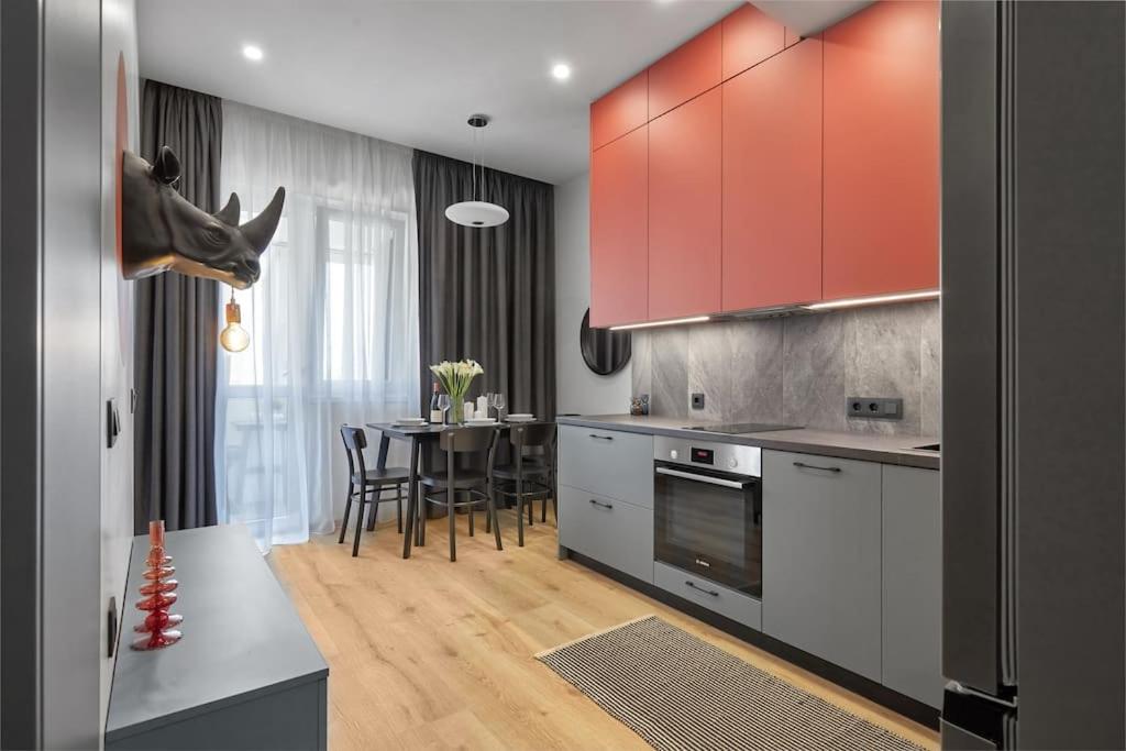 a kitchen with red cabinets and a dining table at Sea Moreto Apartment 2 in Burgas City