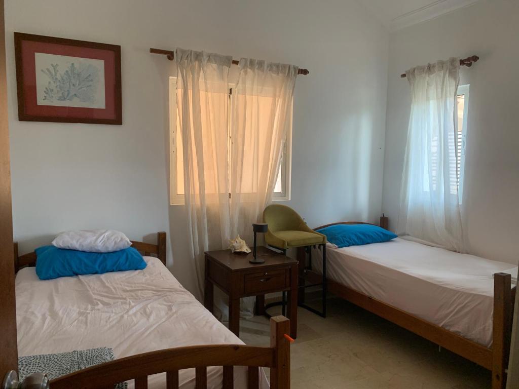 1 Schlafzimmer mit 2 Betten, einem Stuhl und einem Fenster in der Unterkunft Habitación privada en apartamento in Punta Cana