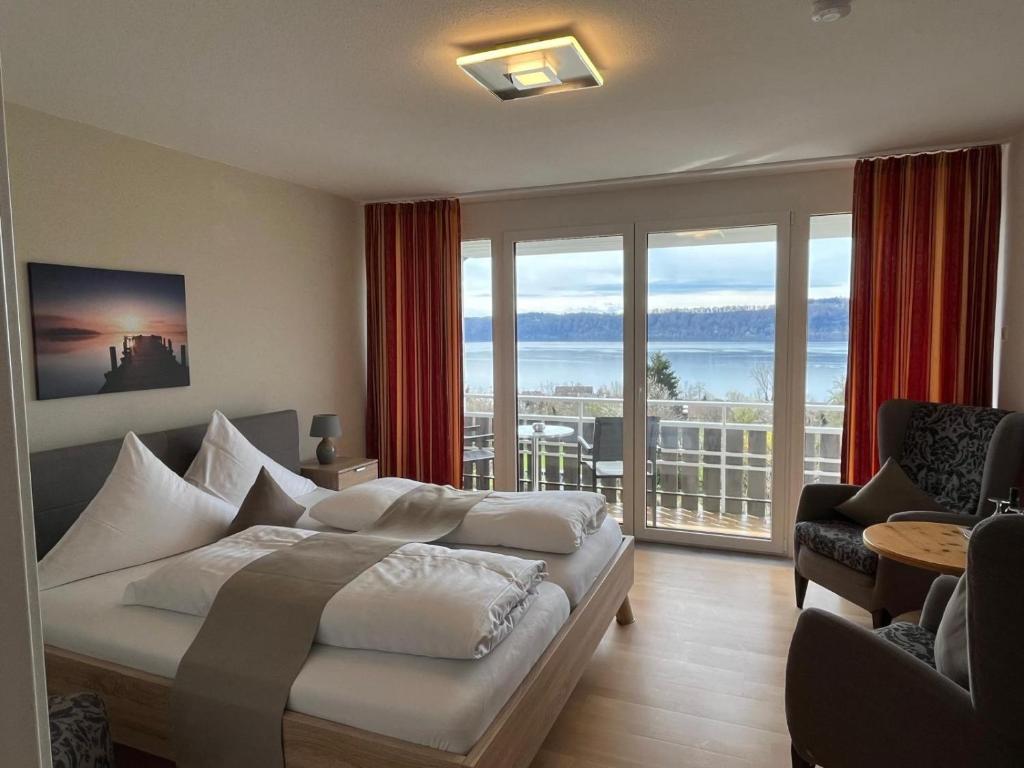 a bedroom with a bed and a balcony with a view at Hotel Landhaus Sternen in Sipplingen